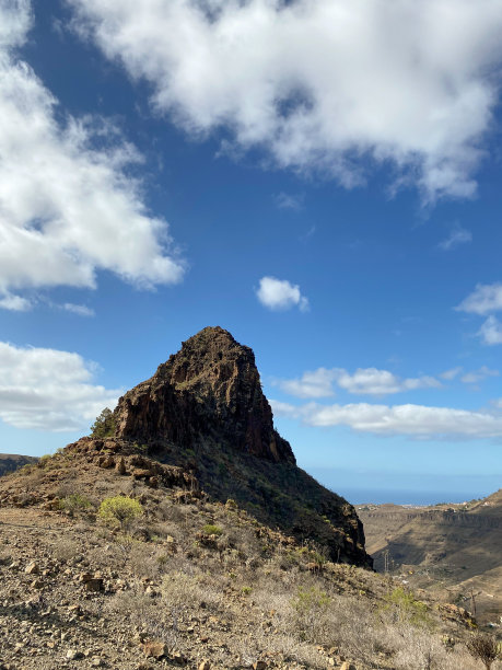日光下岩石山峰的垂直照片图片下载