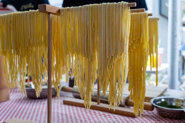 新鲜制作的意大利面挂在意大利面烘干机上的特写，准备制作成一顿伟大的意大利面餐图片下载