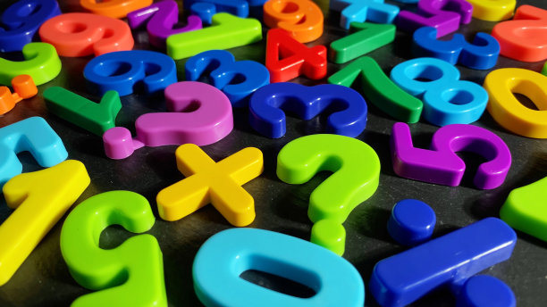 成堆的彩色数字在黑色的石头背景。概念:回到学校，数学。前视图。有选择性的重点图片下载