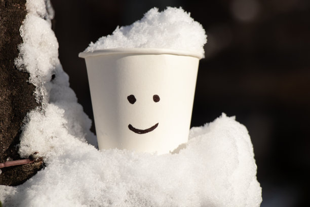 雪中的纸白色玻璃，上面画着微笑图片下载