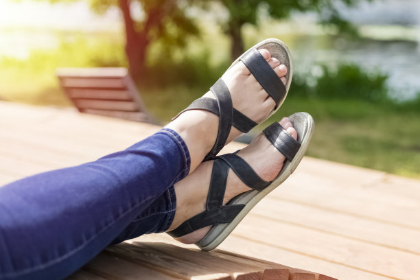 女人穿着鞋子度假，俯瞰大自然，公园。温暖的阳光明媚的日子图片下载