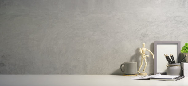 家庭办公室办公桌与笔记本，咖啡杯，盆栽植物和木制假人在白色的桌子上。复制空间为您的广告文本。图片下载