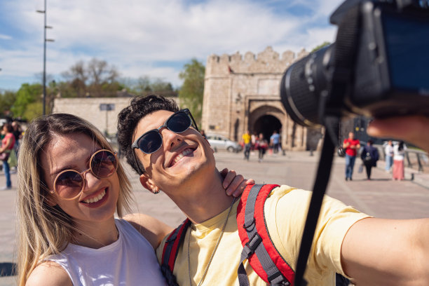 旅行情侣用相机拍视频，同时参观城市图片下载