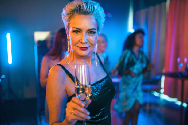 一个成熟迷人的女人拿着香槟杯在酒吧图片下载
