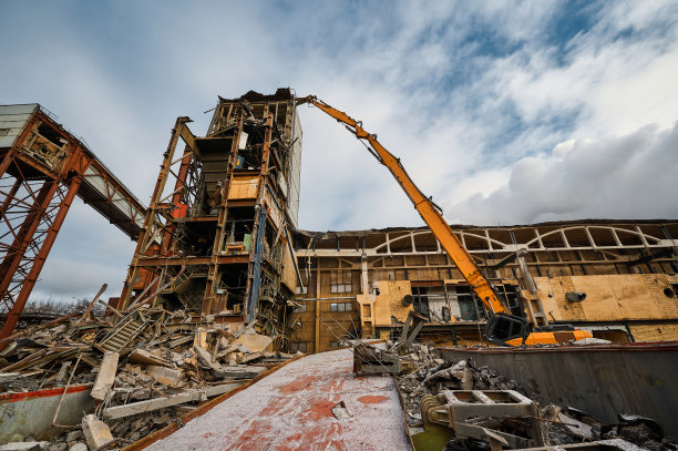 工厂附近有大型机械手的破坏者挖掘机图片下载