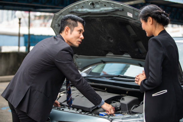 商人在路边帮助检查和修理一个坏女人的车图片下载