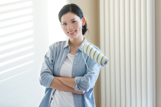 年轻的家庭主妇或单身妇女自己粉刷新房子的墙壁。女性粉刷匠的工作。上半身肖像-库存照片图片下载