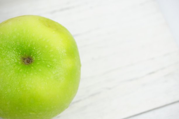 红色和绿色的苹果在木制背景纹理。健康食品的概念图片下载