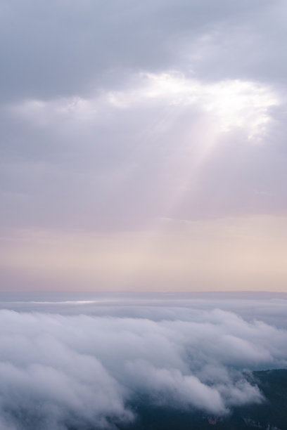 阳光穿过云层，照射到其他云层的顶部。图片下载