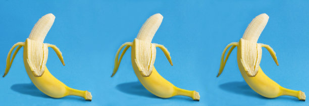 蓝色背景上剥了皮的香蕉。特写镜头。图片下载