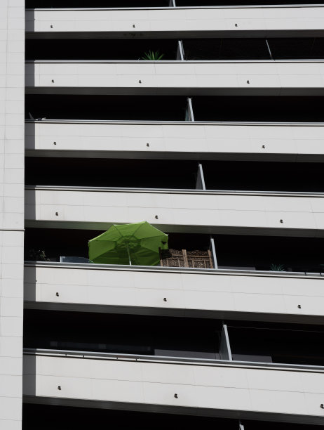 法国巴黎- 2022年10月01日:建筑外立面的白色墙壁和绿色海滩伞图片下载