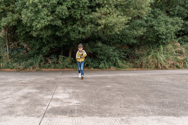 一个亚洲小女孩手里拿着两个木瓜，高兴地跑着图片下载