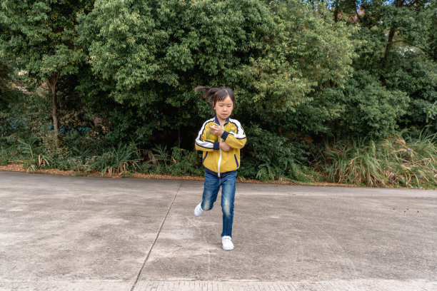 一个亚洲小女孩手里拿着两个木瓜，高兴地跑着图片下载