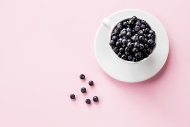 白杯子里的蓝莓。彩色桌上有新鲜多汁的蓝莓陶器。副本的空间。马克杯上有粉色背景的新鲜浆果。挑选新鲜浆果图片下载