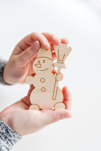 女孩在家里做木制的圣诞饰品，可回收的工艺饰品，新年DIY装饰。艺术家在木制玩具上作画。艺术创造。装饰圣诞舞会图片下载
