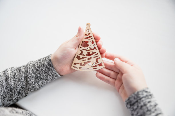 女孩在家里做木制的圣诞饰品，可回收的工艺饰品，新年DIY装饰。艺术家在木制玩具上作画。艺术创造。装饰圣诞舞会图片下载