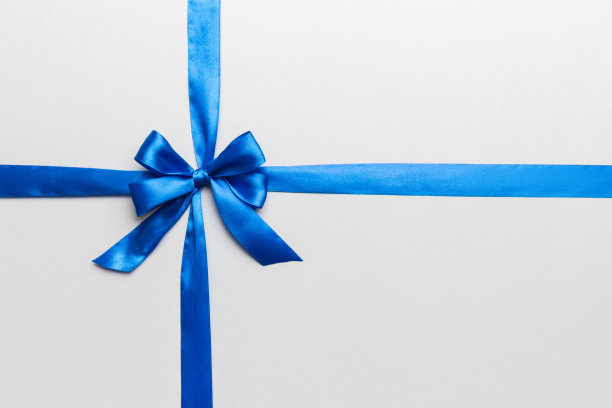 俯视图蓝色丝带卷和蓝色蝴蝶结孤立在彩色背景。平面铺设，复制空间图片下载