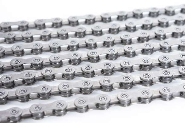 灰色瓷砖石质背景上闪亮肮脏油腻上油的自行车链作为金属自行车设备的一部分。垂直的图像组成图片下载