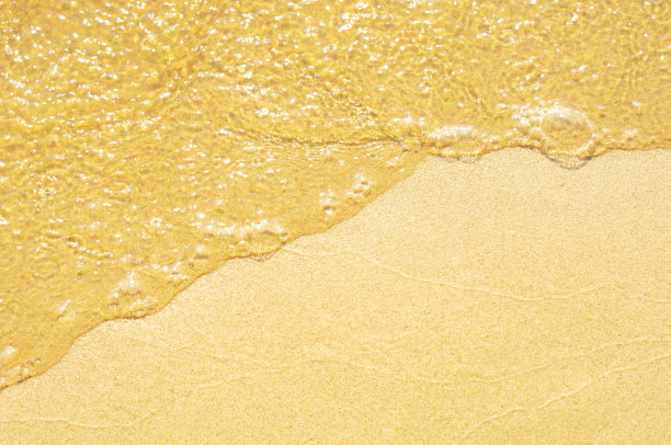 特写镜头中，水从细沙上流过。图片下载