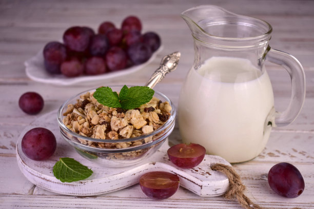 白色背景的葡萄干和牛奶格兰诺拉麦片。健康的早餐。图片下载