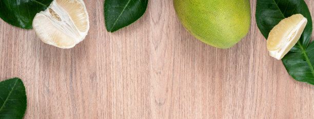 新鲜的柚子水果在明亮的木桌背景。图片下载