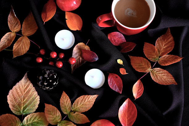 秋天的静物画配上一杯咖啡、蜡烛和酒红色的树叶图片下载