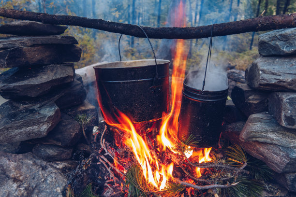 野营锅着火了。户外热气腾腾的食物。野生动物生活方式烹饪美味大餐，Copyspace库存照片图片下载