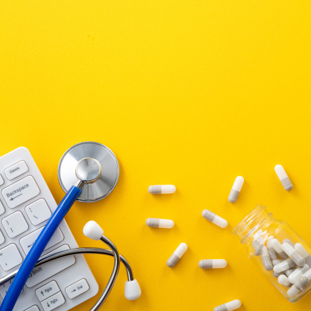 蓝色听诊器配有电脑键盘和胶囊药丸，医学设计理念。图片下载