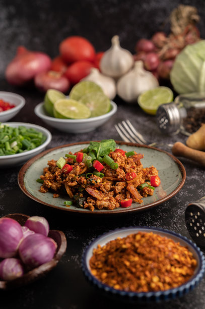 辣猪肉末沙拉配辣椒片、酸橙、葱花、辣椒和烤米饭，在水泥地上放葱花。图片下载