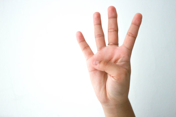 女人第四根手指的特写。白色背景上显示数字4的手指已隔离。副本的空间。图片下载