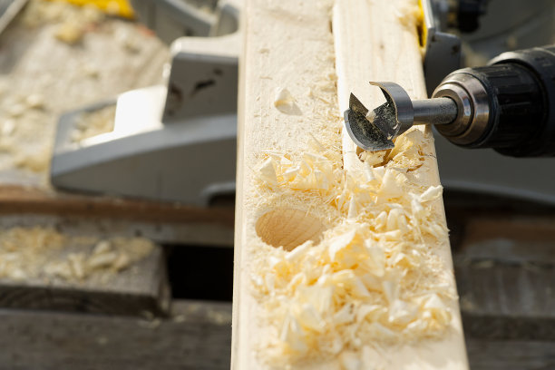 用钻头在木梁上钻孔。图片下载