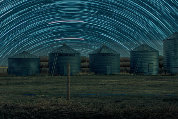 在加拿大阿尔伯塔省的田野里，谷物棚和干草捆图片下载