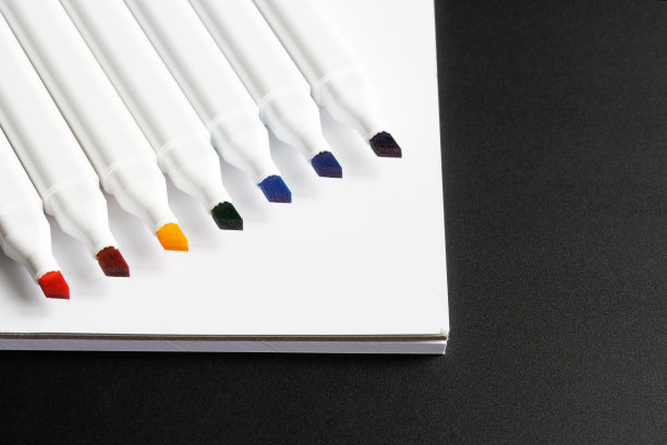 打开彩色毡头标记和黑色背景上的白色记事本。彩虹颜色序列。创意与绘画教学理念。宏。有选择性的重点。图片下载
