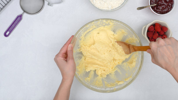 圣诞酥饼配覆盆子蜜饯食谱。厨师在玻璃碗里搅拌食材，从上面近距离观看图片下载