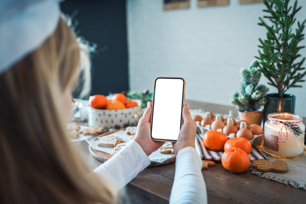 手机与空白屏幕在手中的背景圣诞烹饪。文本。大师班的邀请。圣诞快乐图片下载