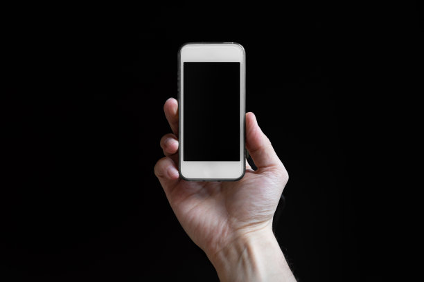 男子手持智能手机，空白屏幕被隔离在黑色背景上。图片下载