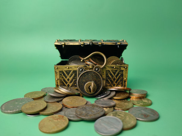 有硬币在软绿色背景的宝盒。图片下载