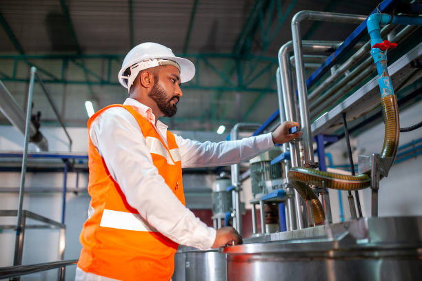 戴安全安全帽的专业技术工程师在工业工厂维护施工设备，工人检查或修理机器。图片下载