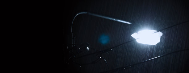 夜与光。雨点落在泰国曼谷8月雨季的夜晚。晚上雨下得很快。淋浴降雨。雨下降。雨滴街灯。天气预报的概念。图片下载