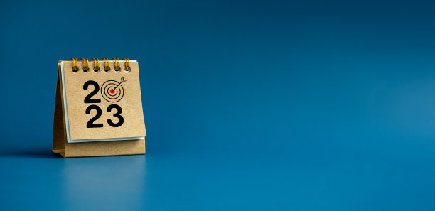 2023年新年快乐横幅背景。2023年数字目标图标米色小台历封面站在蓝色背景与复制空间。商业目标和成功概念。图片下载