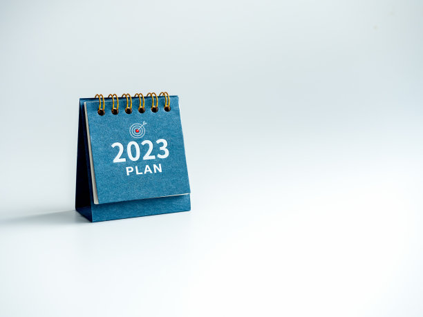 2023年新年快乐背景。2023数字年与文本计划，文字，和目标图标在蓝色台历隔离在白色背景与复制空间，极简。准备好开始一个新的目标。图片下载