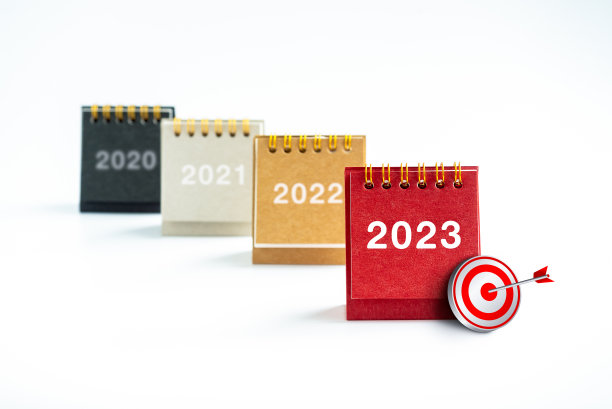 2023年新年数字与3d目标图标在台历封面站在前几年的日历在白色背景。业务目标、领导力、发展和战略计划概念。图片下载