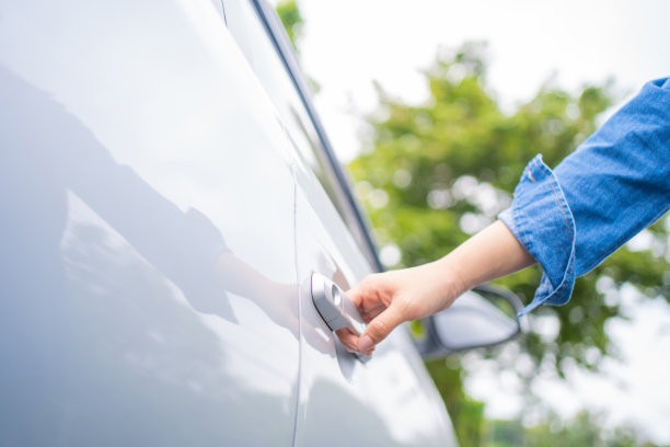 穿着牛仔裤的女人正准备打开车门。图片下载