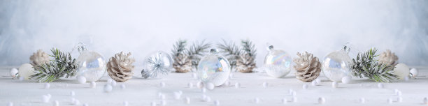 圣诞旗帜与雪松果，透明圣诞球和冷杉树枝在光的背景。冬天或圣诞节的喜庆概念。图片下载