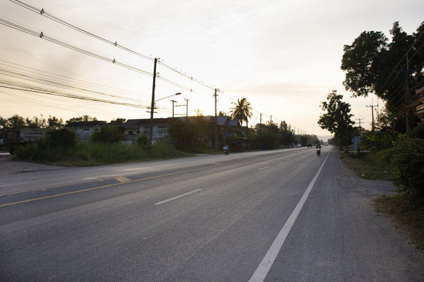 在泰国素可泰的历史公园，黄昏时分在街道和交通道路上开车、骑摩托车、骑自行车，观赏泰国人的景观、城市景观和当地生活方式图片下载