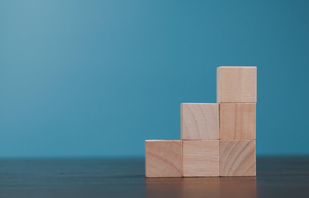 堆叠空白木方块在蓝色背景与复制空间输入文字和信息图表图标。空的棕色木质物体块为符号图标放科技，零重力，经营理念。图片下载
