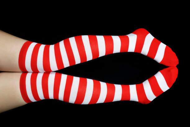 黑色背景下穿着圣诞袜的女人的腿图片下载