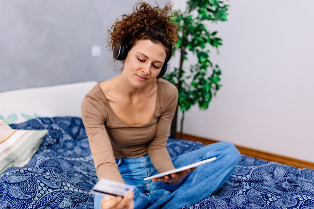 一位年轻女子一边网购一边听音乐图片下载