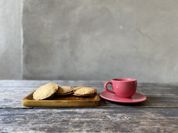 木桌上放着一杯红色的咖啡和饼干图片下载