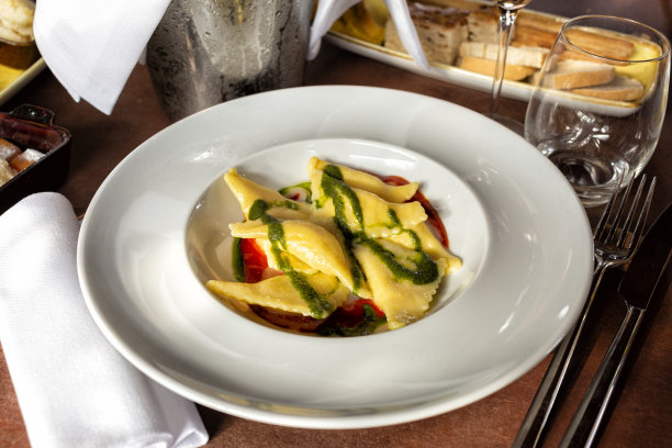 三角形意大利面，意大利饺子或意大利宽面，塞满奶酪，配番茄和罗勒香蒜沙司。生活方式的照片，意大利餐厅的食物。图片下载